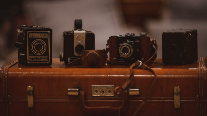 analoge Kameras nebeneinander auf einem Koffer angeordnet